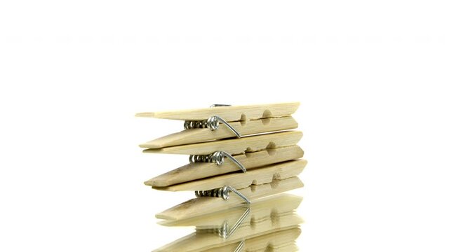 Wooden clothespin for drying clothes rotating on isolated white background. Clothes pin peg in motion. Natural materials concept. Copy text space