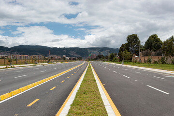 Beauty new avenue with bike path with residential buildings, blue mountains and blue sky at background. 