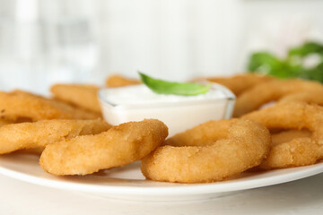 Delicious onion rings with sauce on white wooden table, closeup