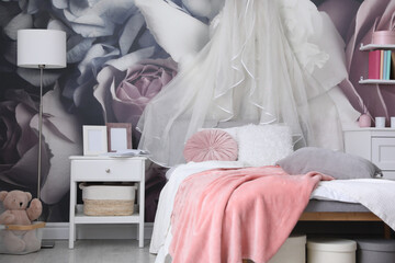 Teenage girl's room interior with comfortable bed and floral wallpaper. Idea for stylish design © New Africa