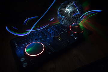 Fototapeta na wymiar DJ console deejay-mixing desk in dark with colorful light. Mixer equipment entertainment DJ station.