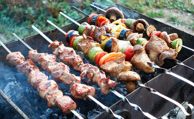 Grilled kebab and vegetables cooking on metal skewer