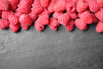 Delicious fresh ripe raspberries on black table, top view. Space for text