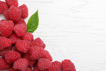 Delicious fresh ripe raspberries on white wooden table, top view. Space for text