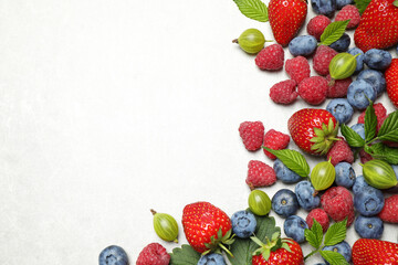 Mix of fresh berries on light table, flat lay. Space for text