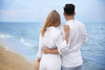 Happy couple having romantic walk on beach