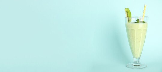 Tasty fresh milk shake with kiwi on light blue background. Space for text
