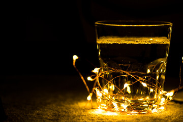 glass cup amidst christmas lights in the dark