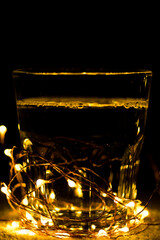 glass cup amidst christmas lights in the dark