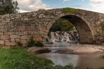 Fototapeta na wymiar Old Roman bridge in the city of Viseu, with the river Pavia flowing under it, Long exposure of water, Viseu, Portugal