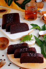 Steamed brownie cake and a cup of tea served on a wooden tray