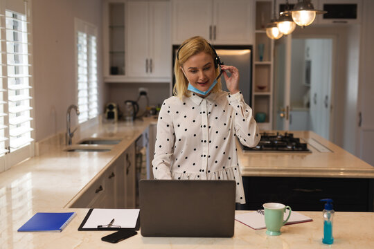 Woman with headset having a video chat on laptop