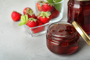 Delicious pickled strawberry jam and fresh berries on light table. Space for text