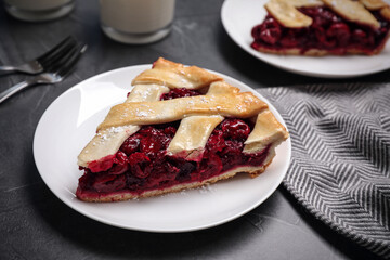 Slice of delicious fresh cherry pie on grey table, closeup