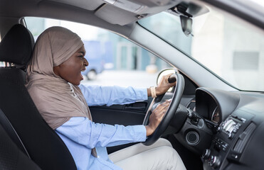 Angry Black Muslim Businesswoman Driving Car, Stuck In Traffic, Emotionally Beeping Horn