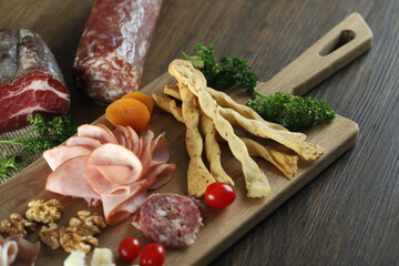 Cheese, parma ham, salami, sirloin, sausage with olives and spices on wooden board