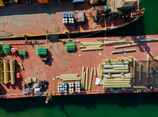 Fototapeta na wymiar Cargo transportation by construction materials transportet building pipes and metal structures on barges