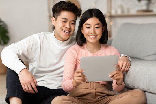 Japanese Spouses Using Tablet Watching Movie Online Relaxing At Home