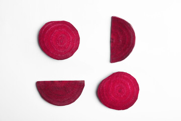 Composition with cut raw beets on white background, top view