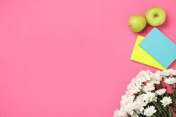 White chrysanthemum flowers, notebooks and apples on pink background, flat lay with space for text....