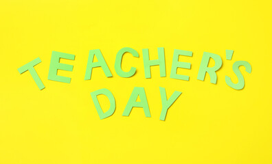 Words TEACHER'S DAY on yellow background, flat lay