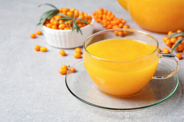 Fresh sea buckthorn tea on light table, closeup