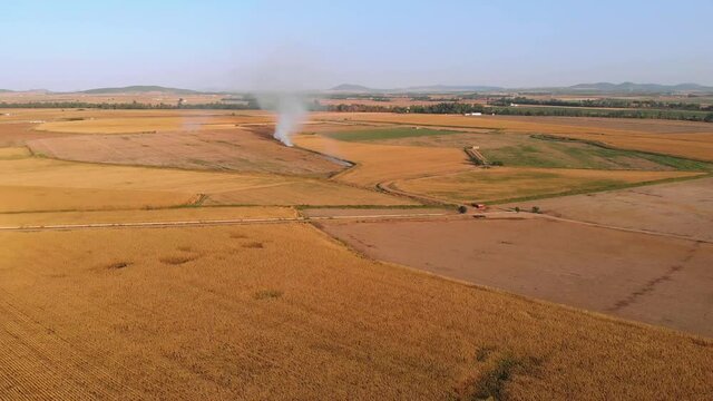 Aerial images of intensive crops. Camera moving away from a stubble fire