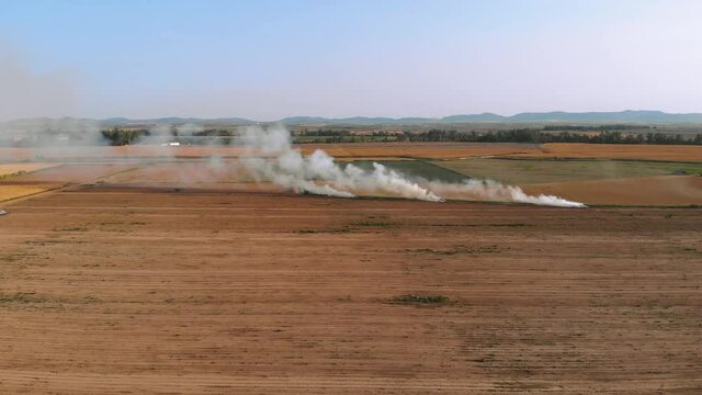 Aerial images with the camera moving perpendicularly approaching the smoke columns of an agricultural fire