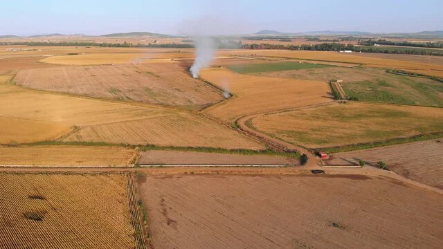 Aerial images of intensive crops. Camera moving further and further away from a stubble fire