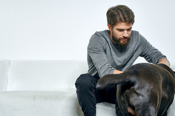 Man with a pet dog on the couch fun friends emotions light room