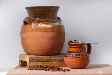 clay pot and jar accompanied by natural coffee beans