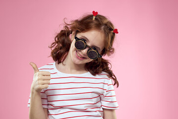 Cute girl sunglasses striped t-shirt lifestyle fun style pink background