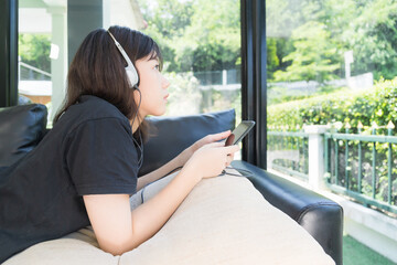 Young girl listening to music from mobile phone in living room