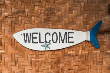 A fish shaped Welcome Signage on a rattan covered wall of a open air restaurant in Bohol.