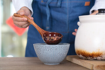 The Chinese in the traditional festival Laba Festival prepare to scoop the boiled Laba congee into a bowl
