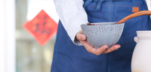 Horizontal composition Chinese people put Laba porridge into a bowl