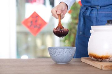 Chinese chef put Laba porridge in casserole into a bowl - obrazy, fototapety, plakaty