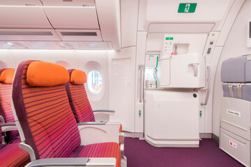 Empty aircraft seats and windows and Emergency exit on an aircraft, view from inside of the plane.