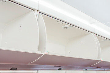 The interior of an airplane cabin with seats, passengers and baggage.