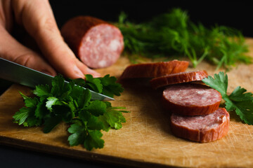 slicing parsley with a kitchen knife on a wooden cutting Board, cooking on the cutting board