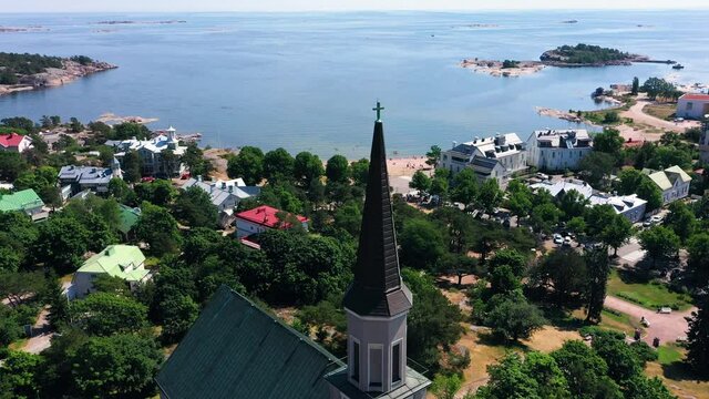 Aerial view around the church, overlooking the boulevard beach and the East harbor in the background, warm, sunny, summer day in Krogars, Hanko, Uusimaa, Finland - orbit, drone shot