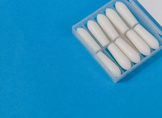 white medicinal candles in a box

white medical candles for intestinal diseases in a transparent box lie on the right with a place for text on the left, top view close-up.