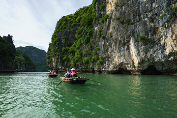 Fototapeta na wymiar Halong bay in Vietnam, UNESCO World Heritage Site, with tourist rowing boats