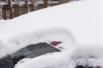 Thick snowflakes piled up after heavy snowfall on an outdoor car