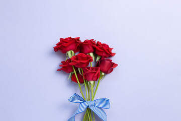 Red rose flowers bouquet on purple background. top view, copy space