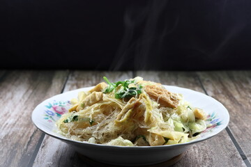 Fried and stirred vermicelli noodle with dried tofu and cabbage seasoning with pepper and soy sauce on the plate. Famous Chinese vegetarian menu in restaurant. 
