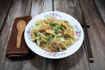 Fried and stirred vermicelli noodle with dried tofu and cabbage seasoning with pepper and soy sauce on the plate. Famous Chinese vegetarian menu in restaurant. 