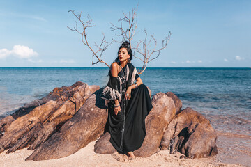 beautiful young stylish tribal woman outdoors on the beach