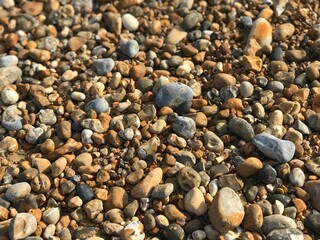 Abstract multi-colored pebbles in beach, natural background and texture. Close-up texture of stones and rocks.