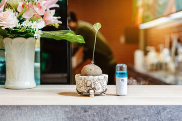 Alcohol nano mist sprayer for hand cleaning to prevent the spread of the Corona virus (Covid-19) to serve customers at coffee shop. Modern health technology. New normal lifestyle. Selective focus